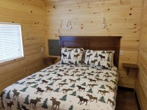 HelperCastle Gate RV Park的一间卧室配有一张带鹿纹被子的床