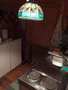 雷丹尼茨恩Cozy Log Cabin near Faaker See的厨房配有水槽和彩色玻璃灯