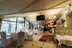 斯摩棱斯克SPA Hotel Veranda的餐厅设有白色的桌椅和电视。