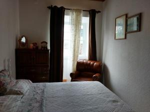 Faja GrandePandora的卧室配有床、椅子和窗户。