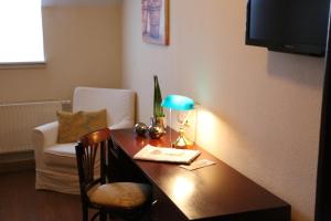 巴德克洛斯特尔劳斯尼茨匹尔萨酒店的客房配有带台灯和椅子的书桌