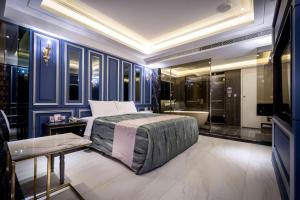 高雄欧阁精品汽车旅馆凤山馆的一间卧室设有蓝色的墙壁、一张床和一个浴缸