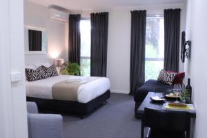 福斯特福斯特舒适客栈的酒店客房配有床、桌子和沙发。