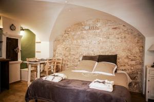 普蒂尼亚诺5号度假屋的一间卧室设有一张大床和石墙
