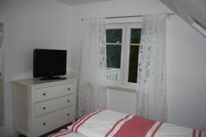 岑平Haus Vineta Wohnung 8的一间卧室设有一张床和一个窗口