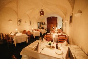 波斯基亚沃Historic Hotel Albrici的餐厅配有桌椅和白色桌布