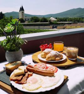 默主歌耶Villa Marinko的一张桌子,上面放着两盘早餐食品和饮料