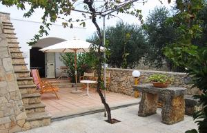 帕图Trullo Salentino的庭院配有遮阳伞和桌椅。