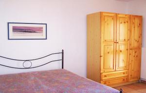 帕图Trullo Salentino的一间卧室配有一张床和一个木制橱柜