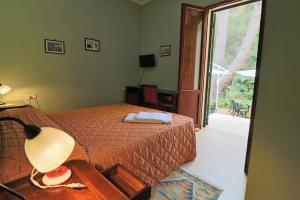加利波利迪莫拉里莱斯棕竹酒店的一间卧室配有一张床和一张带台灯的桌子