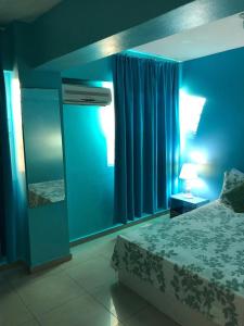 博卡奇卡热门公寓酒店的一间蓝色卧室,配有一张床和镜子