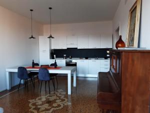 威尼斯Sunrise Apartment in Giudecca的厨房配有桌子和蓝色椅子