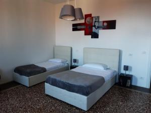 威尼斯Sunrise Apartment in Giudecca的一间卧室设有两张床,墙上挂着一个时钟。