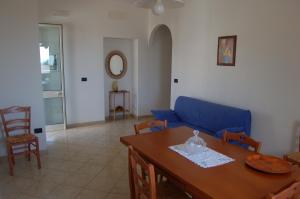 圣凯撒利亚温泉Case Vacanza La Serricella的客厅配有蓝色的沙发和桌子