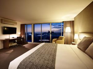 悉尼伦纳德都市酒店的酒店客房配有一张床、一张书桌和一台电视。