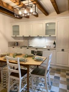代森扎诺-德尔加达Casa La Margherita的厨房配有木桌和白色橱柜。