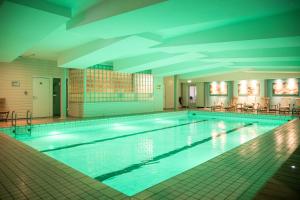 赫尔桑姆Fletcher Hotel-Restaurant Klein Zwitserland的大楼内的大型游泳池