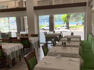 莱科阿尔贝利酒店的餐厅设有白色的桌子和绿色的椅子