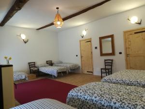 SalabertanoCantina Alpina的一间设有两张床和一张桌子及椅子的房间
