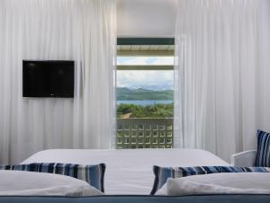 尼基亚娜Thomais Boutique Hotel的酒店客房设有两张床和窗户。
