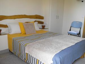 小佩德罗冈A casa do Moinho的一间卧室配有一张大床和一张蓝色椅子