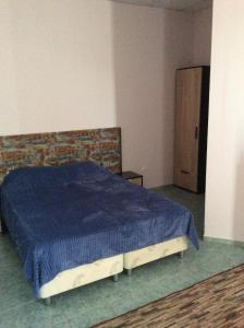 朱布加Отель Идиллия的一间卧室配有一张带蓝色毯子的床