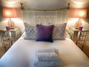 莫顿因马什Century House的一间卧室配有一张带椅子的床和两盏灯。
