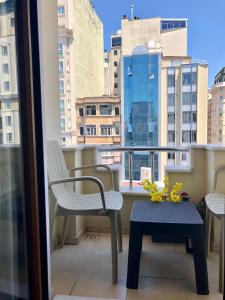 伊斯坦布尔塔克西姆公寓式酒店的阳台配有桌椅和窗户。