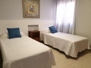 卡勒达德福斯特Sunny & New Apartamento in Caleta de Fuste的客房设有两张床和窗户。
