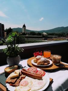默主歌耶Villa Marinko的一张桌子,早餐包括鸡蛋香肠和面包