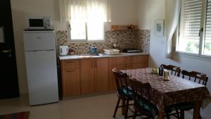 DorBeit Haner Moshav Dor的厨房配有桌子和白色冰箱。
