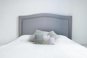 卡尔帕索斯Poseidon Luxury Apartment的白色的床、灰色床头板和枕头
