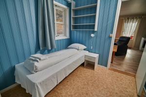 SkjervøySkjervøy Lodge的一间卧室设有一张床和蓝色的墙壁