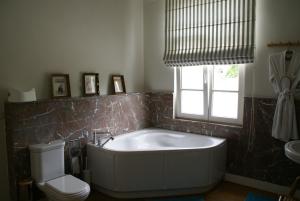 克诺克－海斯特Au Coeur de la Famille的带浴缸、卫生间和窗户的浴室