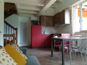 莱德罗Ledro Nest的厨房配有红色橱柜和桌椅