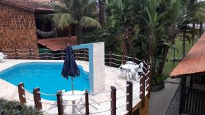 博西坎加Condomínio frente ao mar的一个带遮阳伞和围栏的游泳池