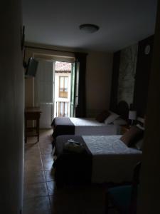 波特斯Casa Favila的酒店客房设有三张床和窗户。