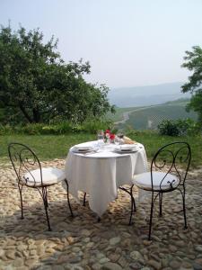Neviglie丁迪纳农家乐的一张桌子、一张白色的桌布和两把椅子