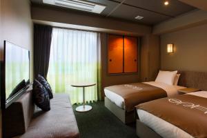 高山eph TAKAYAMA的酒店客房设有两张床和电视。
