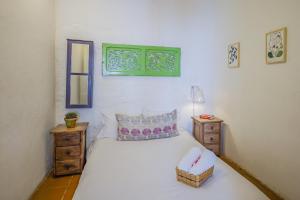 波哥大博坦尼科旅舍的卧室配有一张白色的床,上面有篮子
