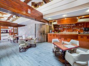墨西哥城Hotel Escala Central del Norte的一间带桌椅的餐厅和一间酒吧
