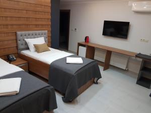 特拉布宗Vera Suite Hotel Trabzon的酒店客房设有两张床和电视。