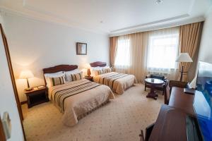 托木斯克玛吉斯切特酒店的酒店客房配有两张床和一张书桌