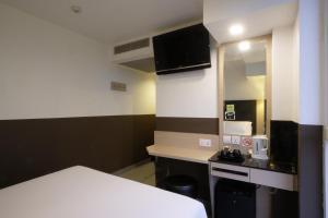 新加坡The Snooze Hotel at Bugis的一间小房间,配有床和小厨房