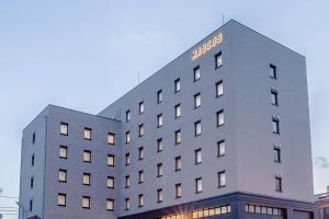 增田MASCOS HOTEL Masuda Onsen的建筑的侧面有标志