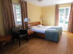 南雪平劳伦蒂酒店的一间卧室配有一张床、一张桌子和一把椅子