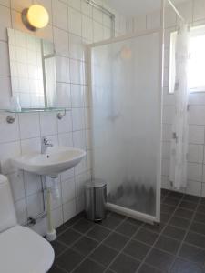 南雪平劳伦蒂酒店的白色的浴室设有水槽和淋浴。