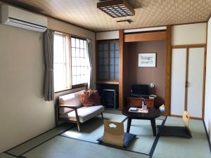 KuroishiTabinoyado Saikawa的客厅配有沙发和桌子