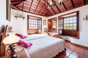 BreñaCasa Rural Fidel的卧室配有一张带粉红色枕头的大床
