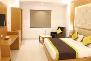 新德里Hotel Aero Star Near Delhi Airport的酒店客房,配有床和投影屏幕
